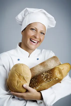 Lachende Bäckerin mit frischem Brot